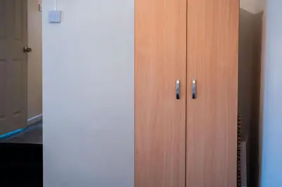 a wooden cabinet with two handles next to a door at Westminster Apartment in Liverpool