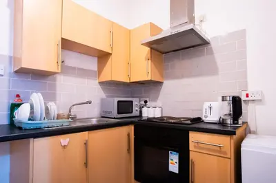a kitchen with wooden cabinets and a sink at Westminster Apartment in Liverpool