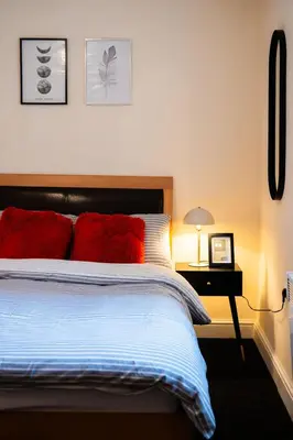 a bedroom with a bed with red pillows on it at Westminster Apartment in Liverpool
