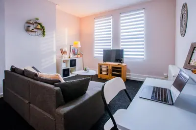 a living room with a couch and a laptop on a table at Westminster Apartment in Liverpool