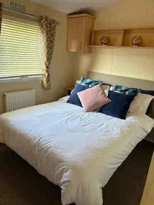 a large white bed with pillows on top of it at J&D by the sea in Heysham