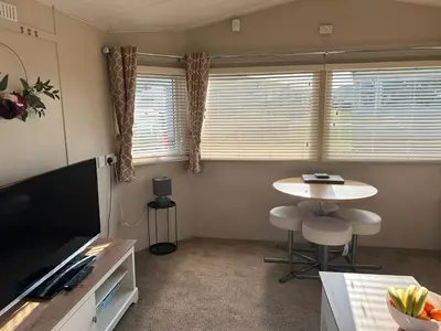 a small living room with a table and a television at J&D by the sea in Heysham
