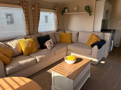 a living room with a gray couch with yellow pillows at J&D by the sea in Heysham