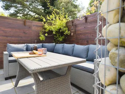 a table and a blue couch on a patio at Luxury 18th Century Stone Built Cottage in Lower Bentham