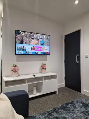 a living room with a tv on a wall at Luxury house in Kensington for 21 guests in Liverpool
