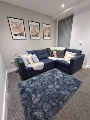 a living room with a blue couch and a rug at Luxury house in Kensington for 21 guests in Liverpool