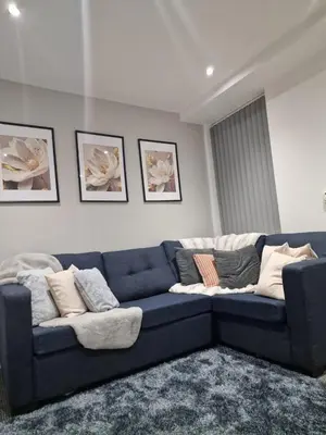 a blue couch in a living room with pillows at Luxury house in Kensington for 21 guests in Liverpool