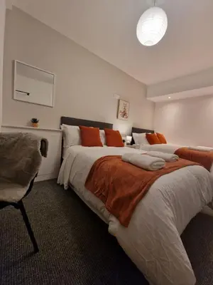 a bedroom with two beds and a chair at Luxury house in Kensington for 21 guests in Liverpool
