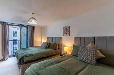 a bedroom with two beds and a window at Top Floor City Stay Beatles Bars & Nightlife in Liverpool