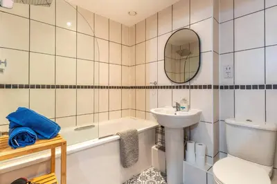 a bathroom with a sink and a tub and a toilet at Top Floor City Stay Beatles Bars & Nightlife in Liverpool