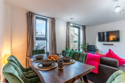 a living room with a table and a couch at Top Floor City Stay Beatles Bars & Nightlife in Liverpool