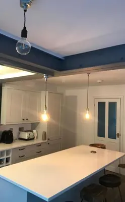 a kitchen with a white counter and some lights at Williamson House Lancaster in Lancaster