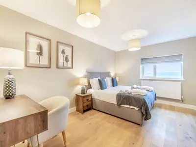 a bedroom with a bed and a chair and a window at Cherry Tree Cottage - Uk47756 in Mellor