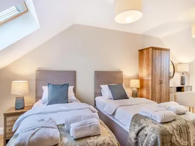 two twin beds in a room with two lamps at Cherry Tree Cottage - Uk47756 in Mellor