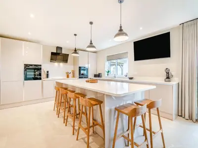 a kitchen with a large white island with bar stools at Cherry Tree Cottage - Uk47756 in Mellor
