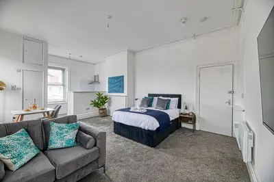 a bedroom with a bed and a couch at Glendale House by Guestz in Lytham St Annes