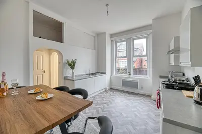 a kitchen and dining room with a wooden table and chairs at Glendale House by Guestz in Lytham St Annes