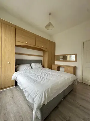 a bedroom with a large bed with white sheets at Abigail house in Westhoughton