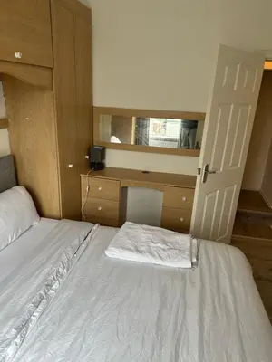 a small bedroom with a bed and a dresser at Abigail house in Westhoughton