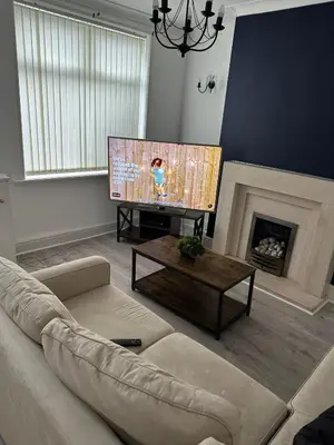 a living room with a couch and a flat screen tv at Abigail house in Westhoughton