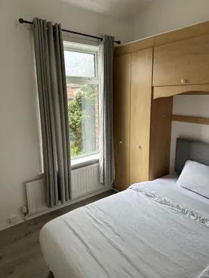 a bedroom with a large bed and a window at Abigail house in Westhoughton