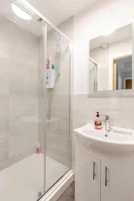 a white bathroom with a shower and a sink at Liverpool City Haven 1-Bed Apartment for Couples & Solo Travelers in Liverpool