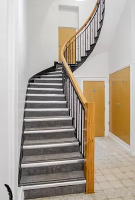 a winding staircase in a home with wooden railings at Liverpool City Haven 1-Bed Apartment for Couples & Solo Travelers in Liverpool