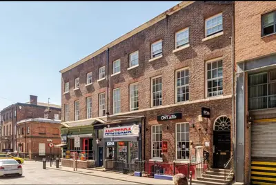 a large brick building on a city street at Liverpool City Haven 1-Bed Apartment for Couples & Solo Travelers in Liverpool