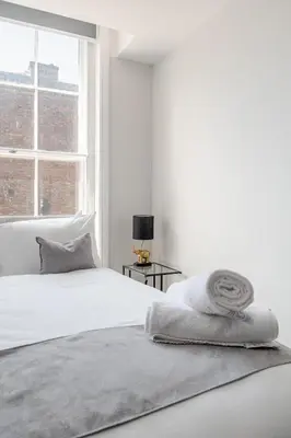 a white bedroom with a bed and a window at Liverpool City Haven 1-Bed Apartment for Couples & Solo Travelers in Liverpool
