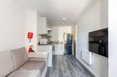 a living room with a couch and a kitchen at Modern 1-Bedroom City Centre Apartment, Liverpool Hideaway in Liverpool