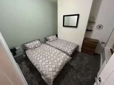 a small bedroom with a bed and a mirror at Entire House - 4 Bed - Sleeps 6 in Clayton le Moors