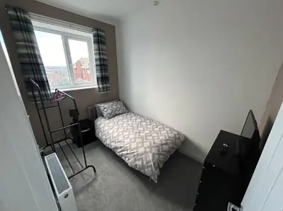 a bedroom with a bed and a window at Entire House - 4 Bed - Sleeps 6 in Clayton le Moors