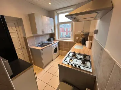 a small kitchen with a stove and a sink at Entire House - 4 Bed - Sleeps 6 in Clayton le Moors