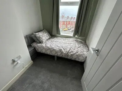 a small bed in a small room with a window at Entire House - 4 Bed - Sleeps 6 in Clayton le Moors