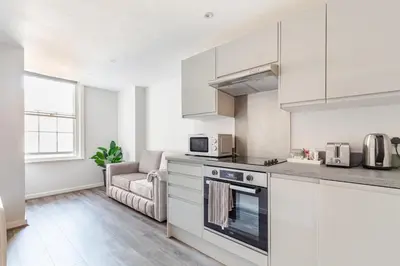 a kitchen with white cabinets and a stove top oven at Liverpool Nightlife Spot City Centre 1BD apartment and Sofa bed in Liverpool
