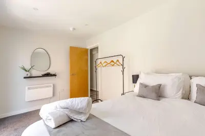 a bedroom with a large white bed and a mirror at Bright 1-Bed Apartment In City Centre Liverpool in Liverpool