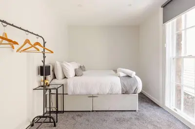 a white bedroom with a bed and a window at Bright 1-Bed Apartment In City Centre Liverpool in Liverpool