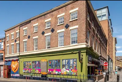 a large brick building with a store in front of it at City Comfort Modern 1-Bed Apartment sleeps up to 4 in Liverpool
