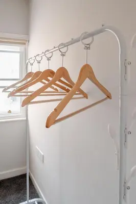a rack of wooden hangers in a room at 1-BD Apartment with Sofa Bed In The Heart of Liverpool in Liverpool