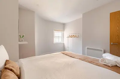 a white bedroom with a large bed in a room at 1-BD Apartment with Sofa Bed In The Heart of Liverpool in Liverpool
