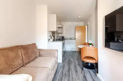 a living room with a couch and a kitchen at 1-BD Apartment with Sofa Bed In The Heart of Liverpool in Liverpool
