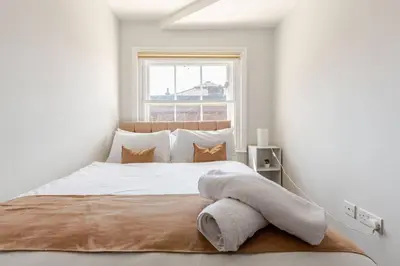 a white bedroom with a large bed with a window at Liverpool City Stay 1-Bed apartment with 2 Sofa Beds, Sleeps up to 6 in Liverpool