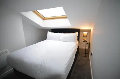 a bedroom with a white bed with a skylight at Walk to City Hotspots Liverpool 1BD Apartment in Liverpool