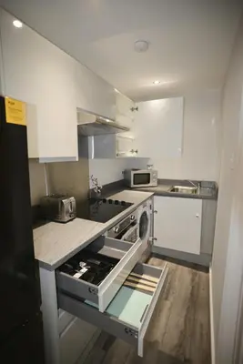 a kitchen with white cabinets and a stove top oven at Walk to City Hotspots Liverpool 1BD Apartment in Liverpool