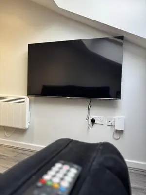 a flat screen tv on a wall with a remote control at Walk to City Hotspots Liverpool 1BD Apartment in Liverpool