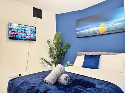 a bedroom with a bed with a tv on the wall at TV in Every Room Free Parking in Liverpool