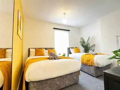 two beds in a room with yellow and white at TV in Every Room Free Parking in Liverpool