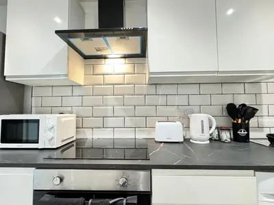 a kitchen with white cabinets and a counter top at Contractors and Groups with Parking in Liverpool