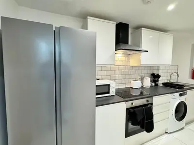 a white kitchen with a refrigerator and a microwave at Contractors and Groups with Parking in Liverpool