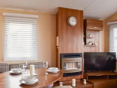 a living room with a table and a television at Stay And Sea in Heysham